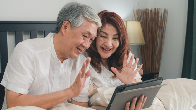 Asian senior couple using tablet at home. asian senior chinese  grandparents, video call talking with family grandchild kids while lying on  bed in bedroom at home in the morning concept. Free Photo -