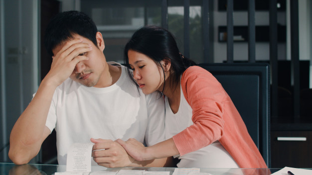 Young asian pregnant couple records of income and expenses at home. dad  worried, serious, stress while record budget, tax, financial document  working in living room at home . Free Photo - Nohat -